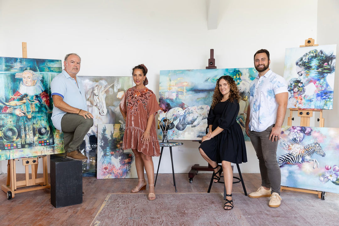 Elli, John, Jake, and Dimitra pose in front of several of their paintings