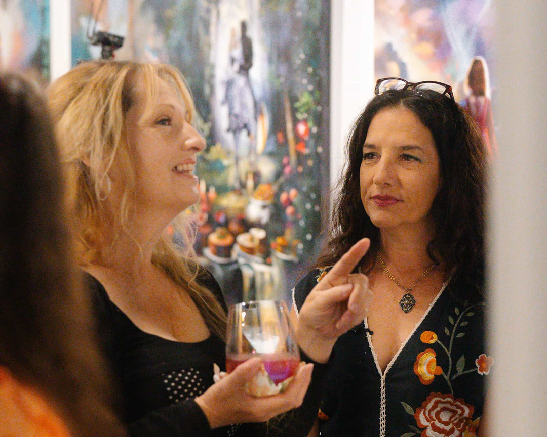 Artist Elli Milan listens thoughtfully to an admirer of her work.