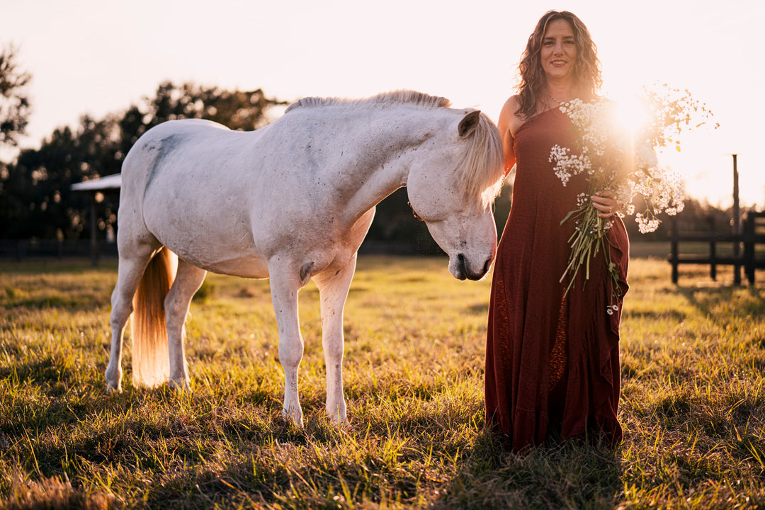 Elli Milan stands with her icelandic horse, Solomon in a field during dusk