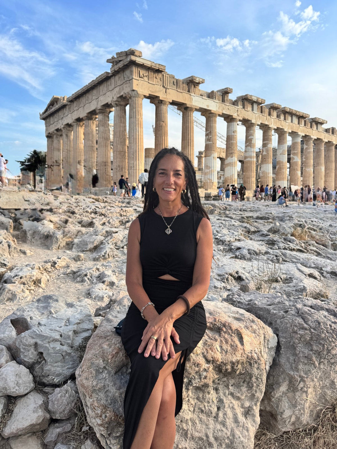 Elli Milan sitting on a rock in front of the Parthenon on the Acropolis in Athens, Greece