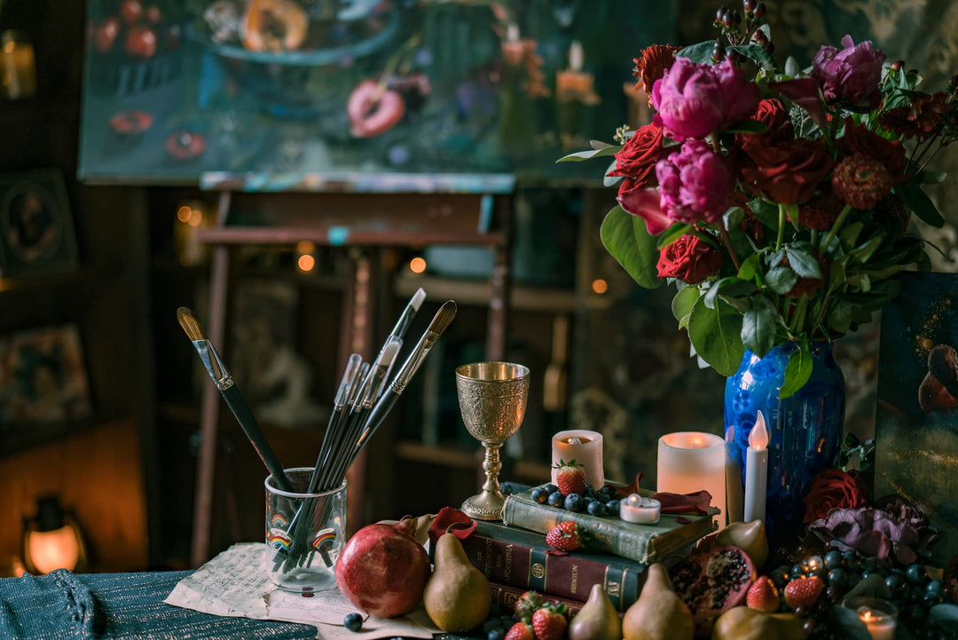 A closeup of flowers, paintbrushes, and other objects in Elli's studio